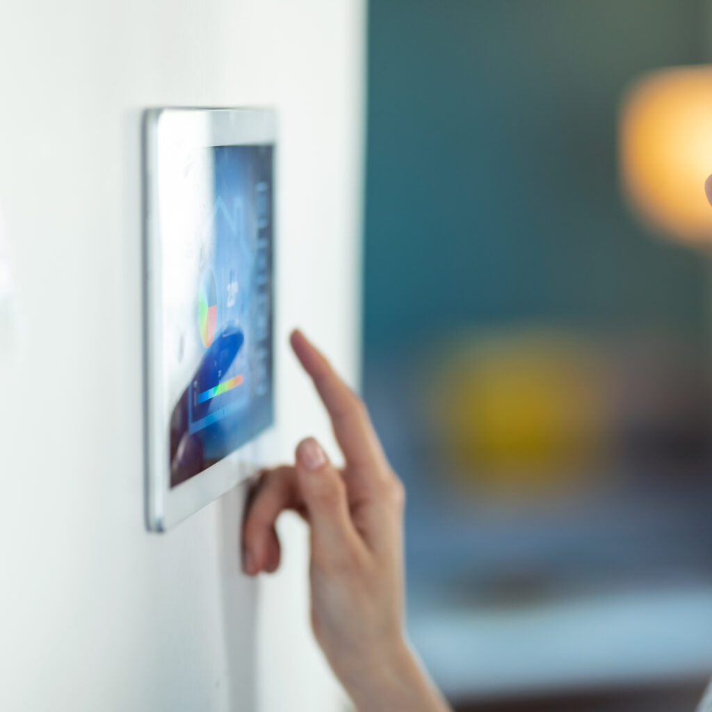 Shot of pretty young woman using the home automation system on digital tablet to regulate the temperature.