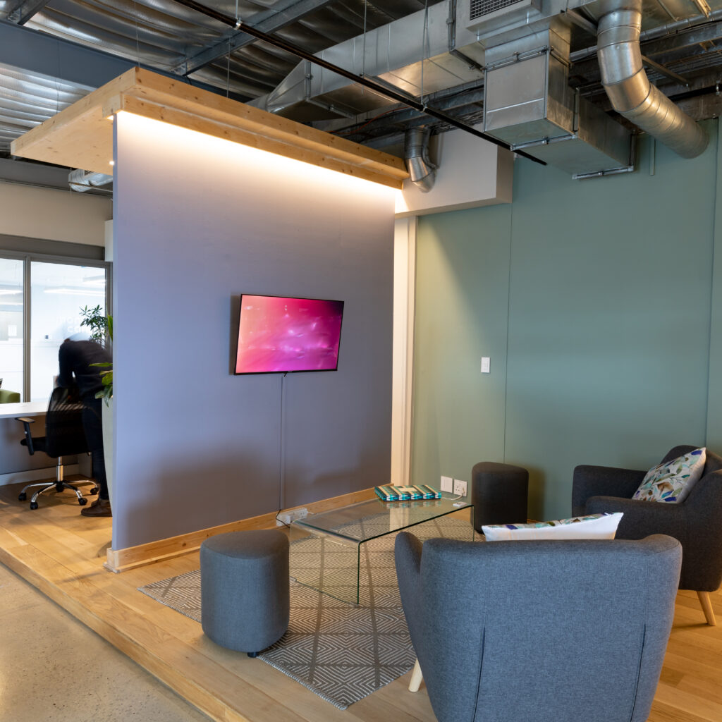 Armchairs in front of television set in lobby of modern illuminated office. business and office workplace.